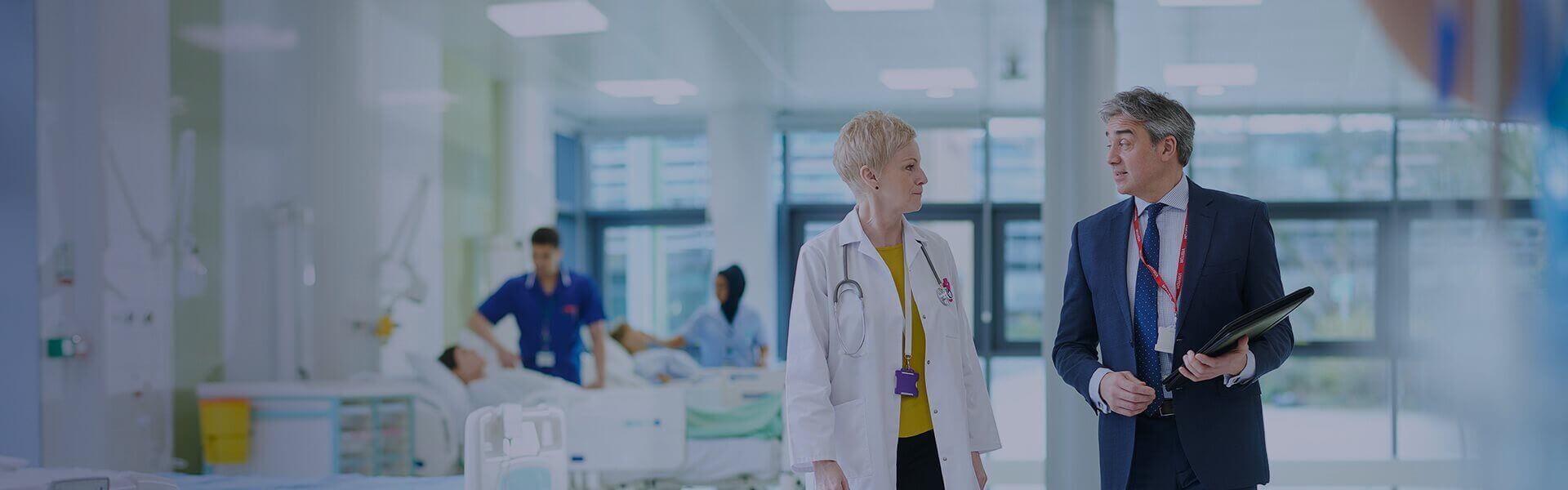 Image of a doctor and consultant walking out of a hospital ward