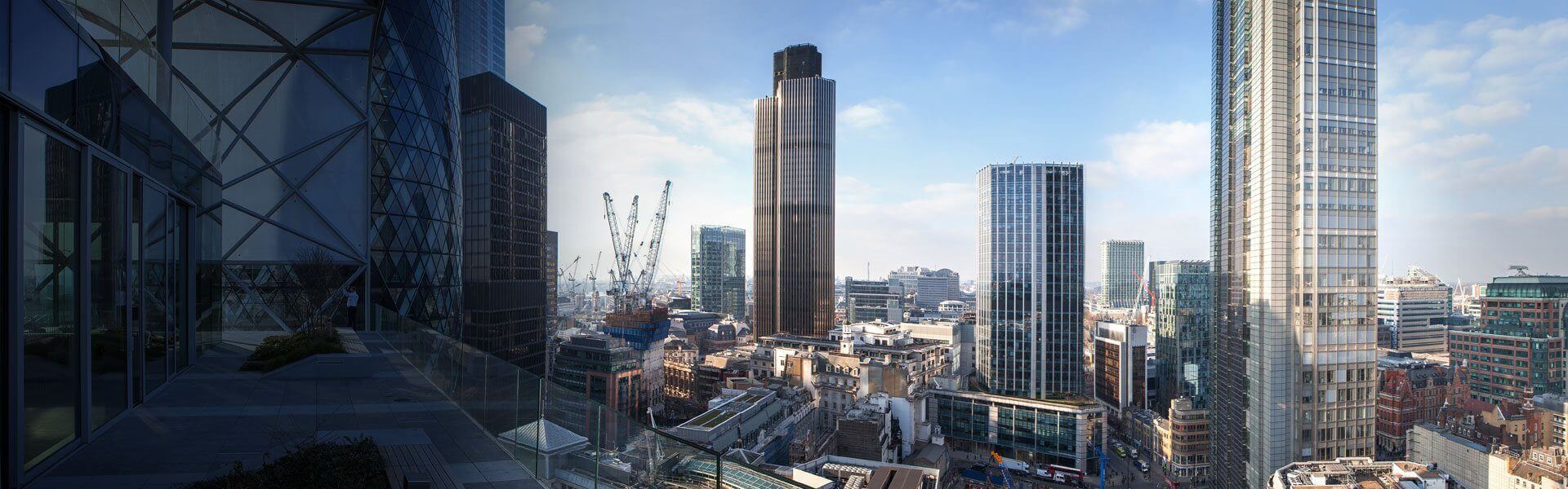 Image d'une partie de l'équipe du groupe français sur le balcon du bureau de Londres, avec vue sur les toits de Londres derrière