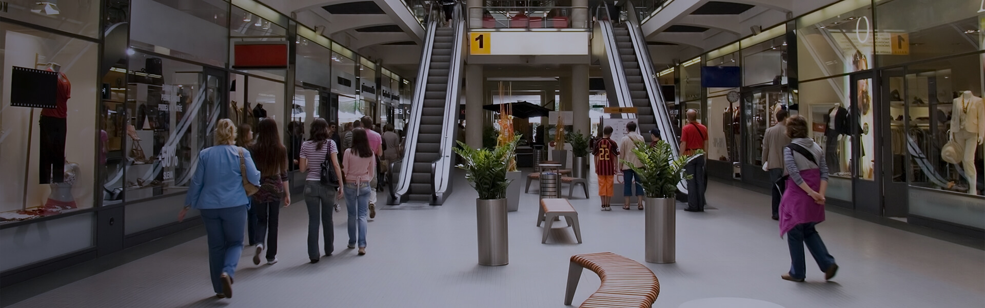 Image of a busy shopping centre with escalators