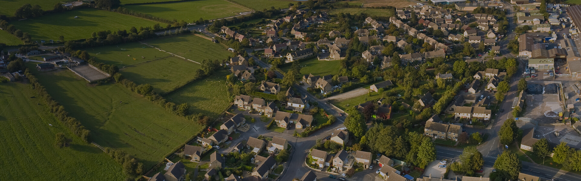 Image of aerial view of fields and rural buildings, including farms and housing