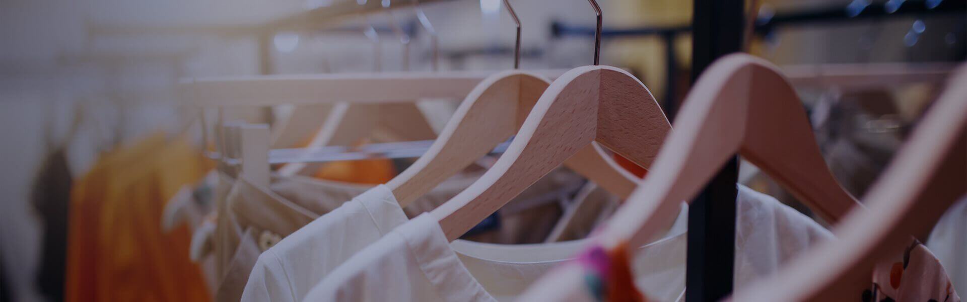 Image of clothes hanging on a rail in a retail shop