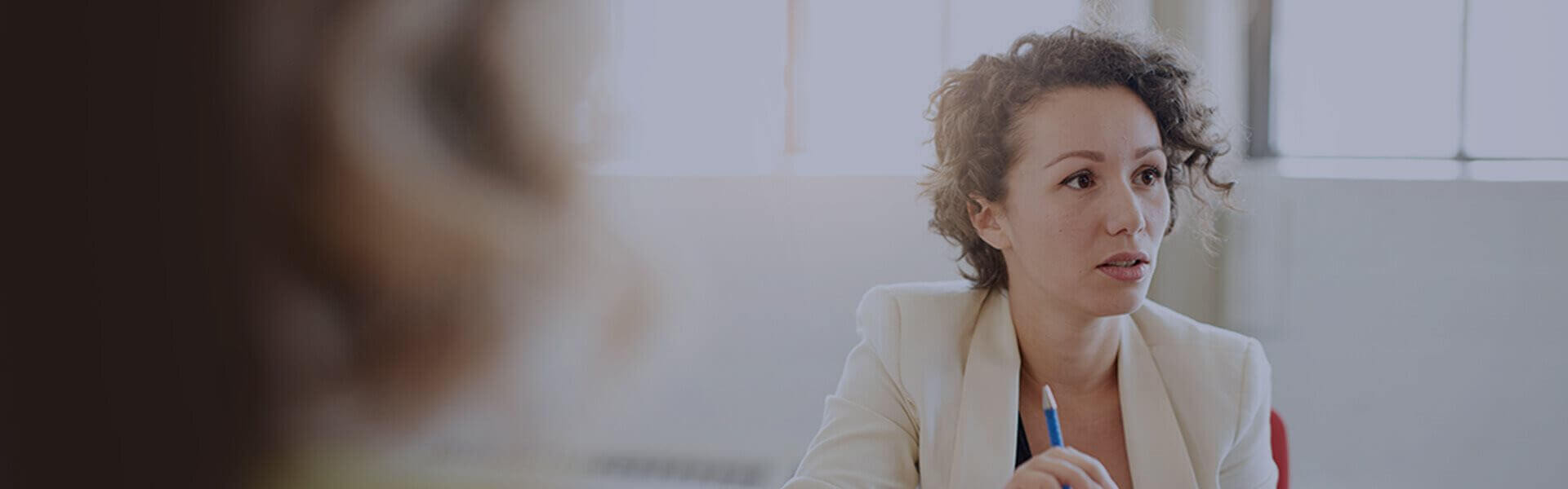 Image of person in a meeting holding a pencil