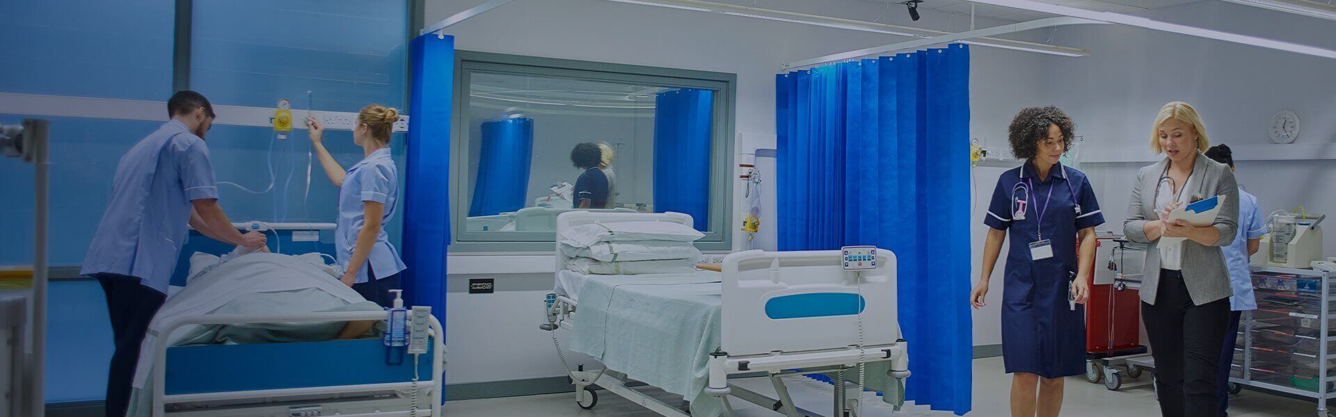 Image of a busy hospital ward with staff and patients