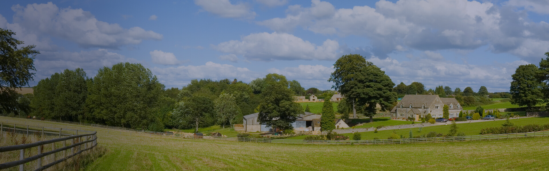 Image of farm house, and buildings surrounded by rolling hills of fields